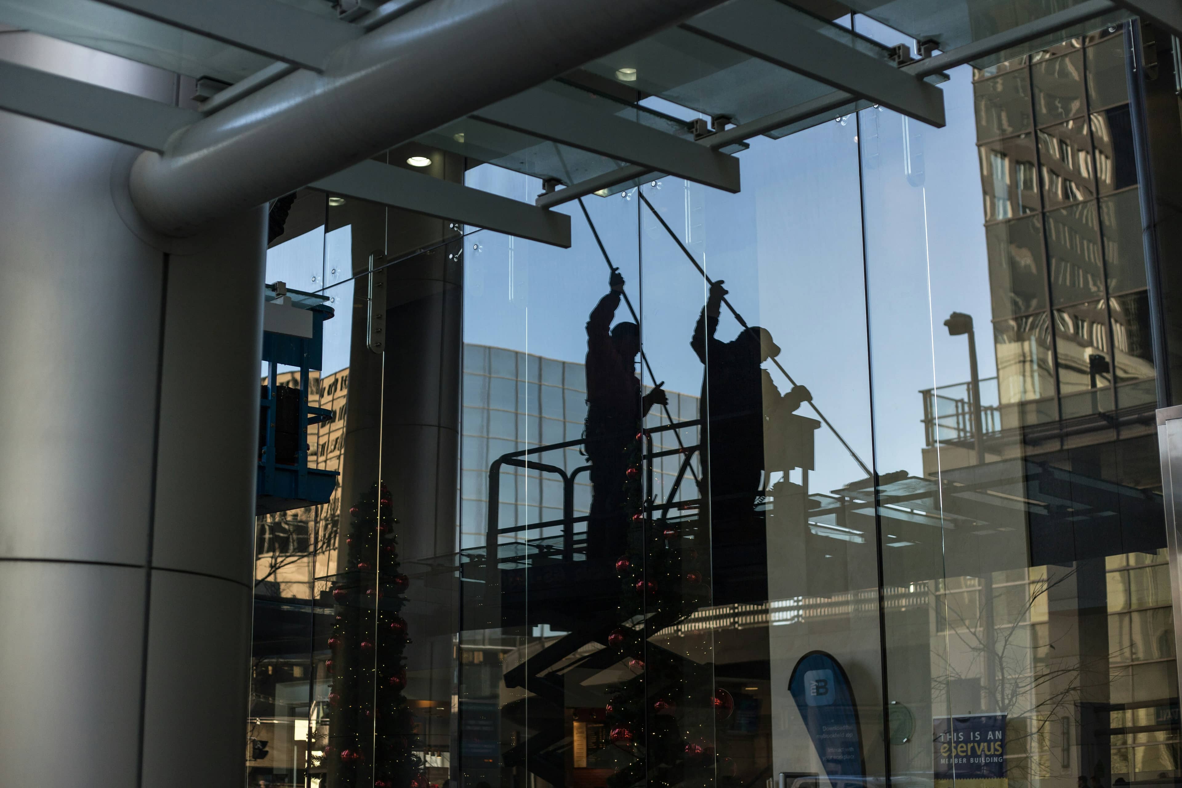 Zwei Personen arbeiten hinter einer großen Glasfront.