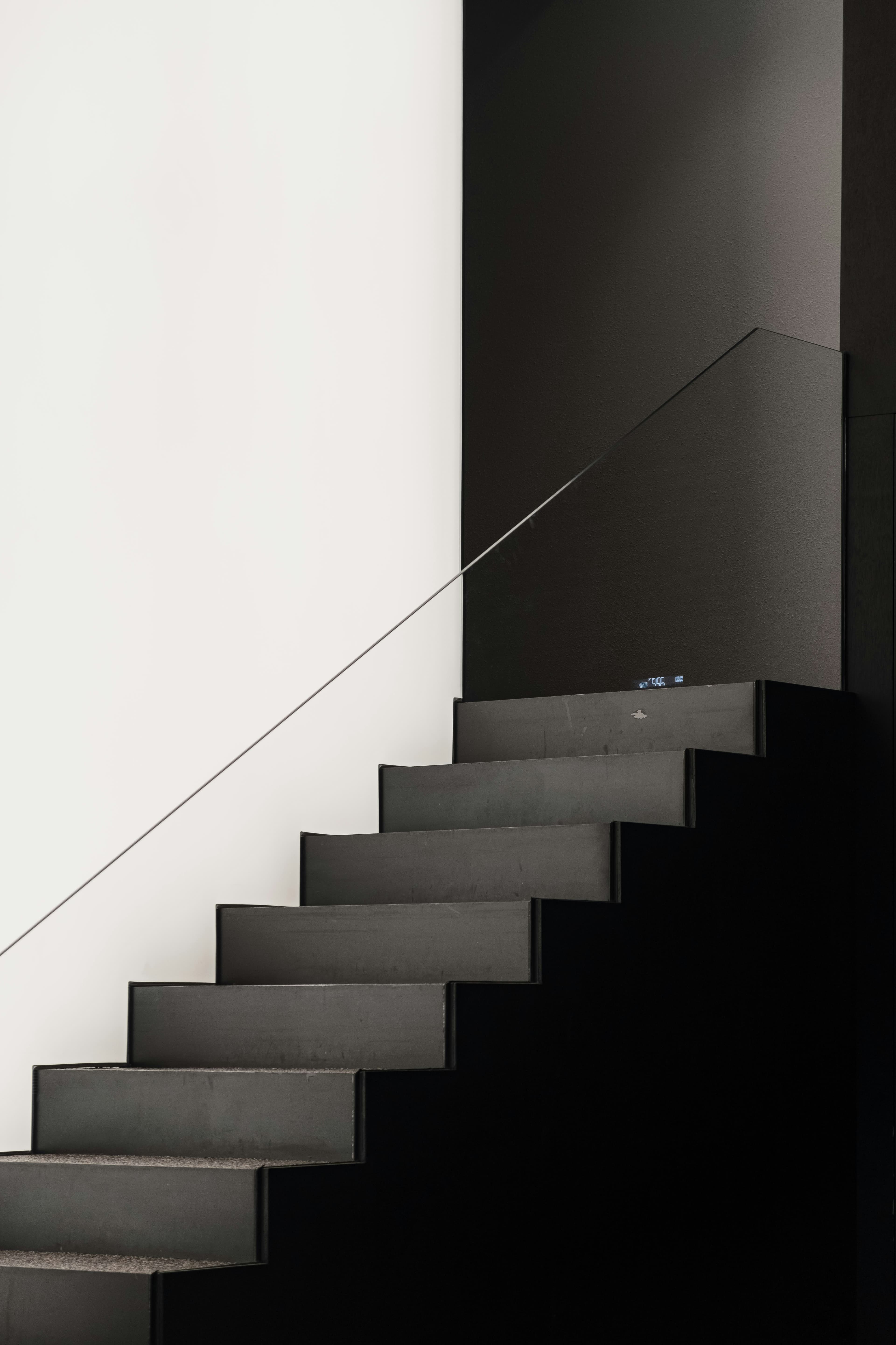 Dunkle Betontreppe vor heller Wand.